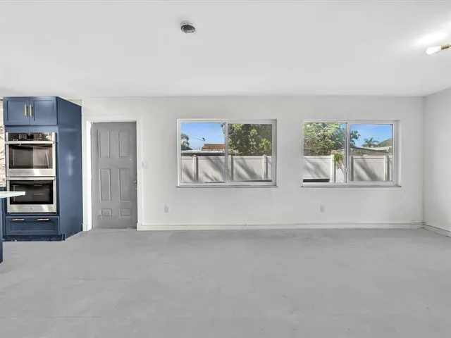 a kitchen with stainless steel appliances kitchen island granite countertop a table and chairs in it