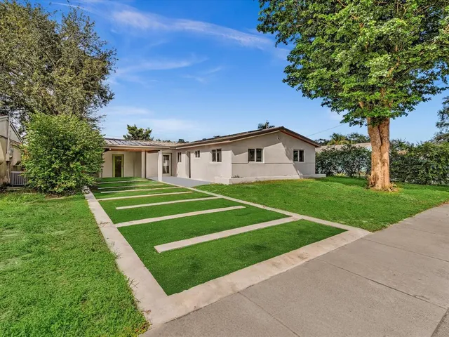 a house with green field in front of it