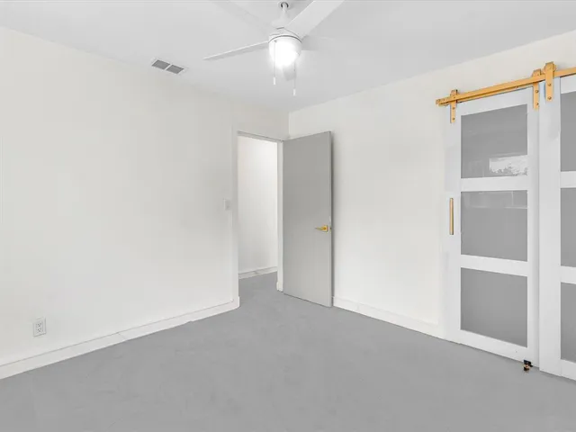 a view of a backyard with grass and a large tree