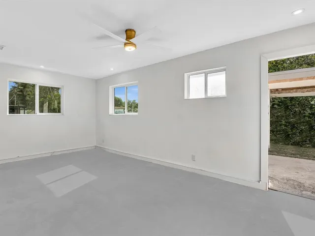 an aerial view of residential houses with outdoor space and trees