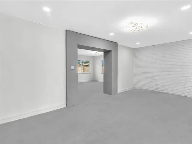 a view of an empty room with closet and a window