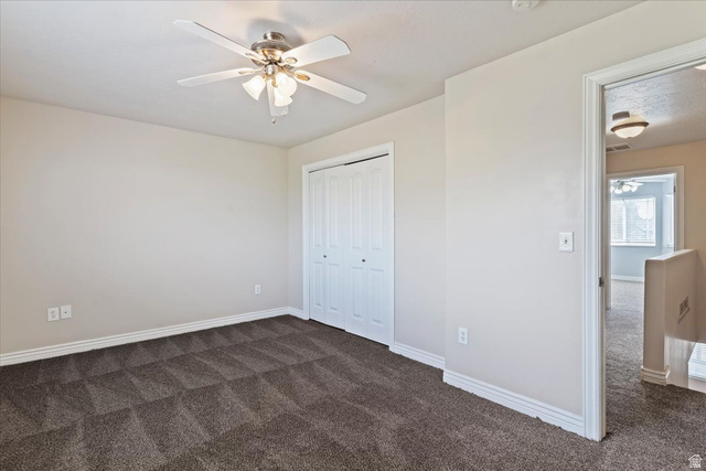 2350 South Highway 89, Unit 4 Perry, UT 84302 - Photo 22 of 30 Unfurnished bedroom with dark colored carpet, a closet, and a ceiling fan