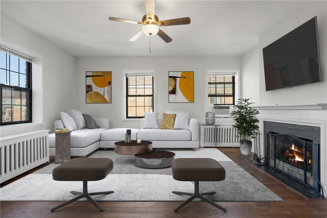 Virtually staged living room with radiator, ceiling fan, and fireplace