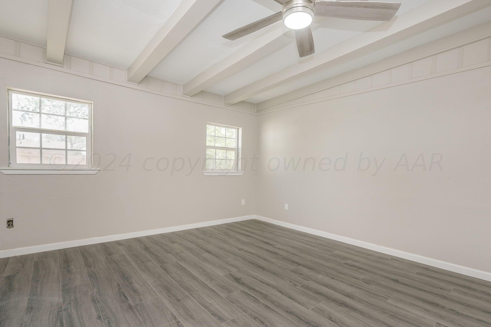 4013 South Jackson Street Amarillo, TX 79110 - Photo 12 of 18 an empty room with wooden floor fan and windows
