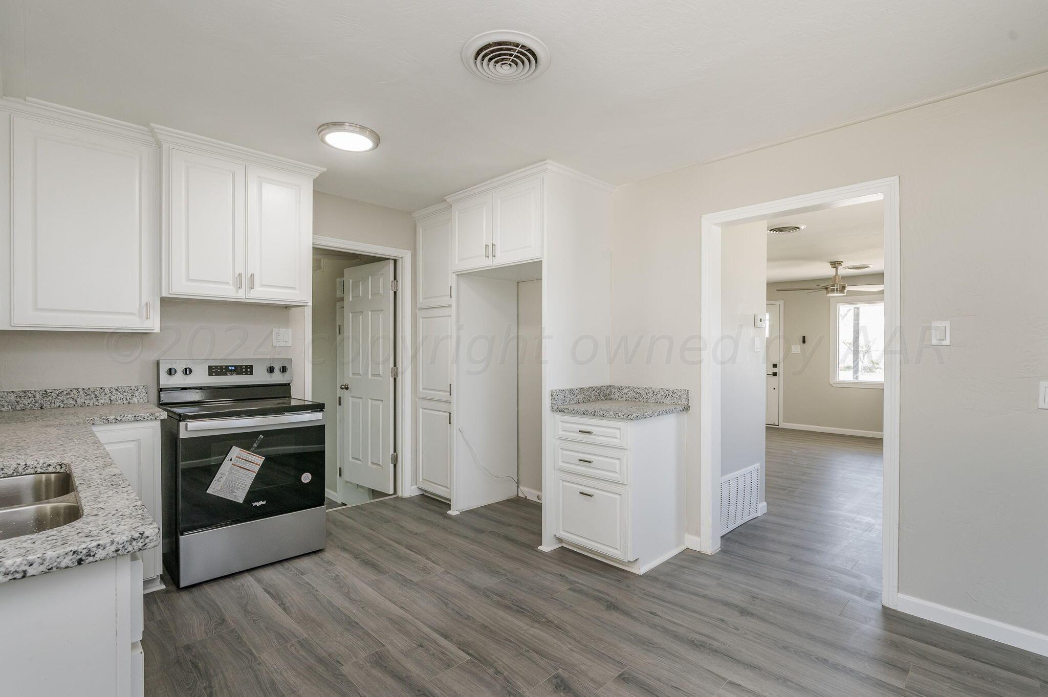 4013 South Jackson Street Amarillo, TX 79110 - Photo 4 of 18 a kitchen with granite countertop a stove top oven and cabinets