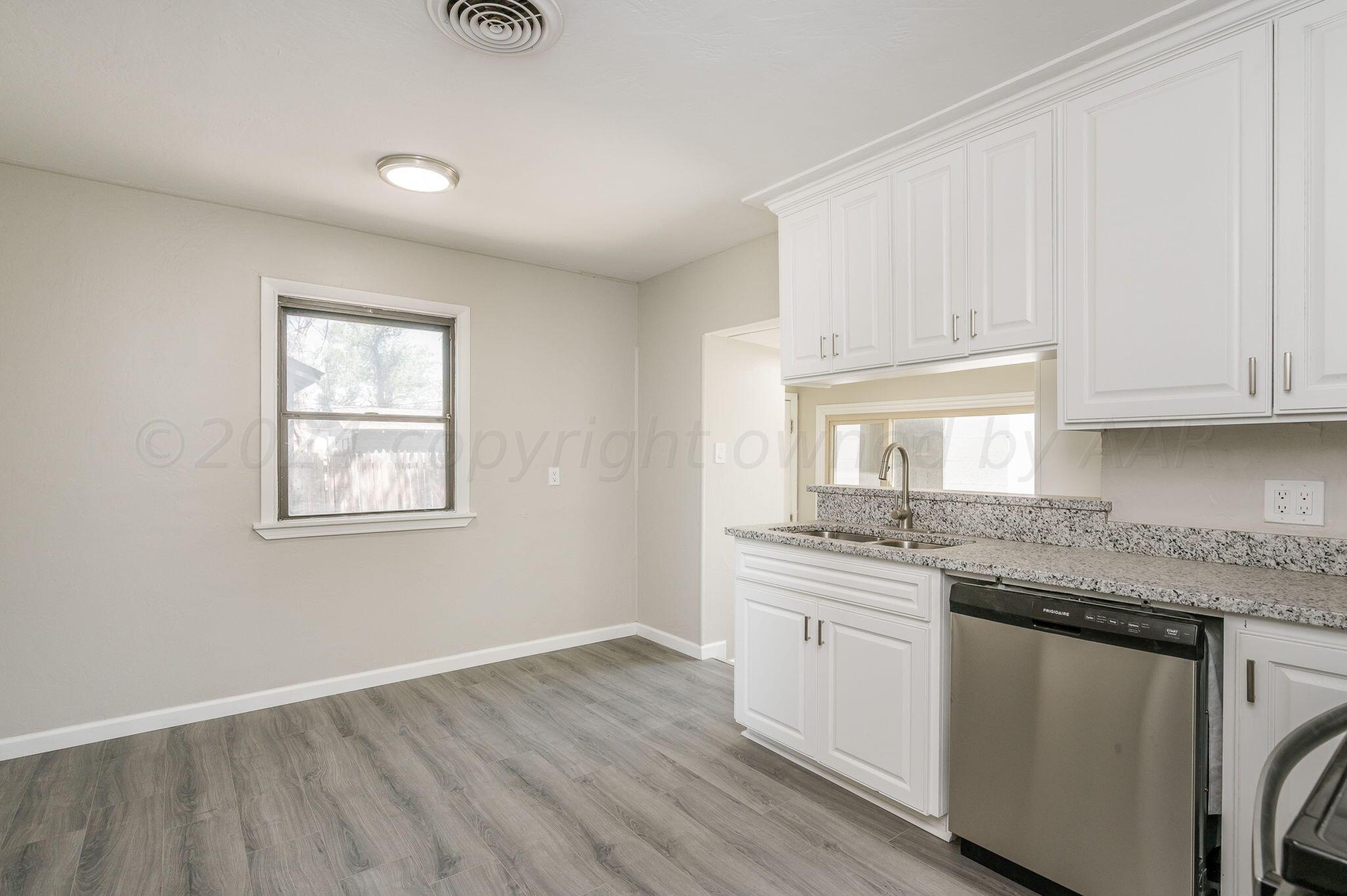 4013 South Jackson Street Amarillo, TX 79110 - Photo 5 of 18 a kitchen with granite countertop stainless steel appliances a sink and cabinets