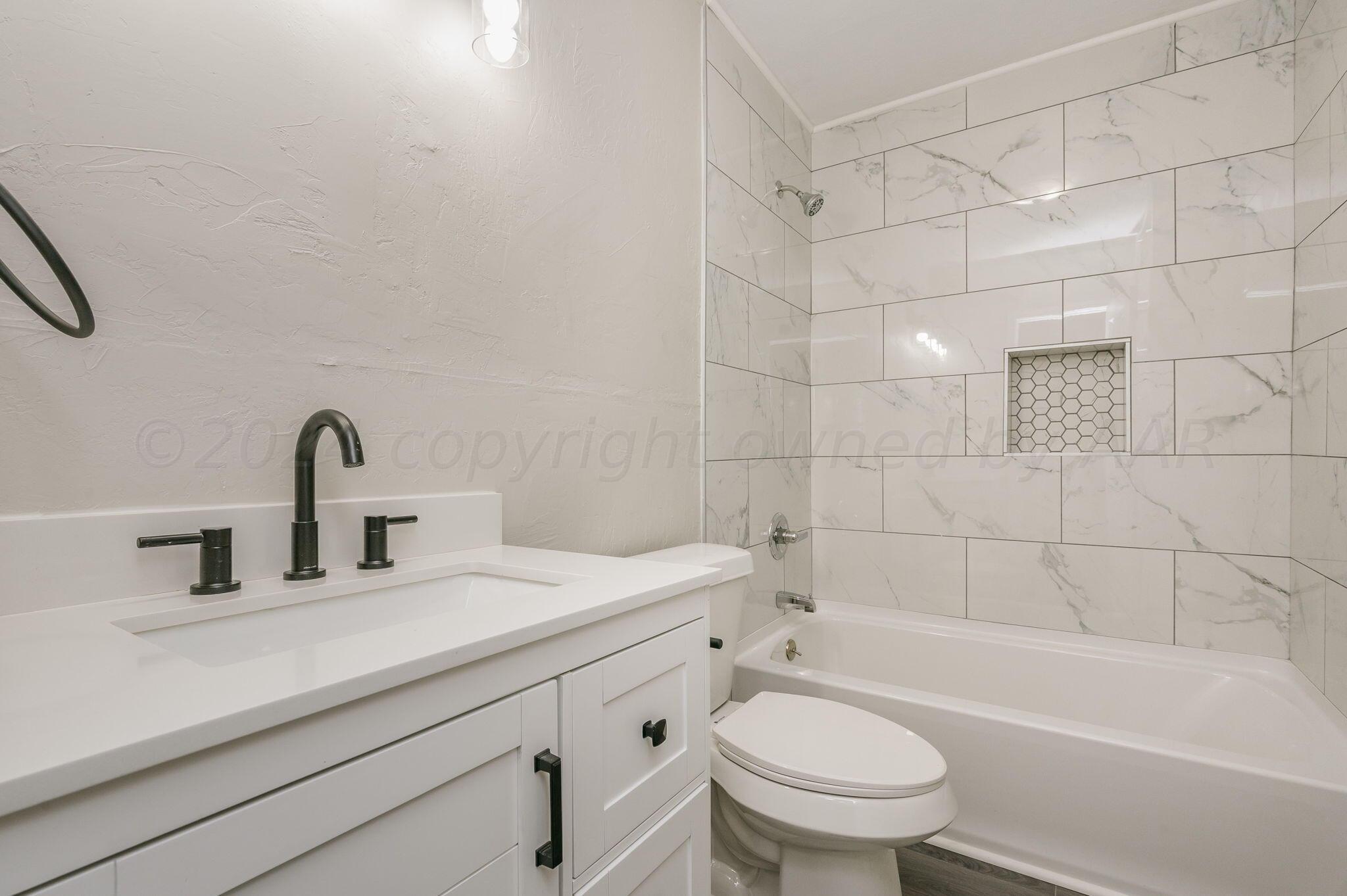 4013 South Jackson Street Amarillo, TX 79110 - Photo 10 of 18 a bathroom with a sink a toilet and a bathtub