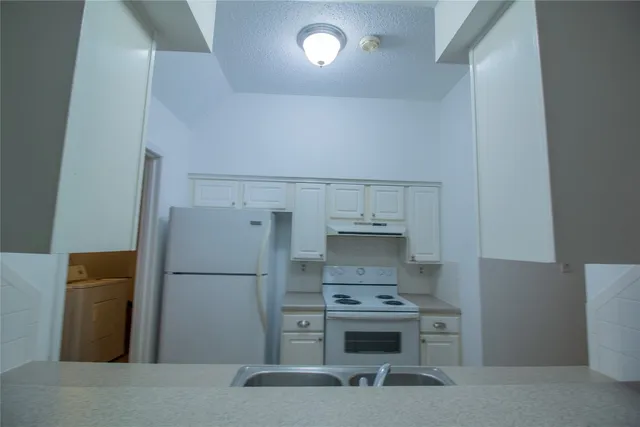 a kitchen with a refrigerator and a stove