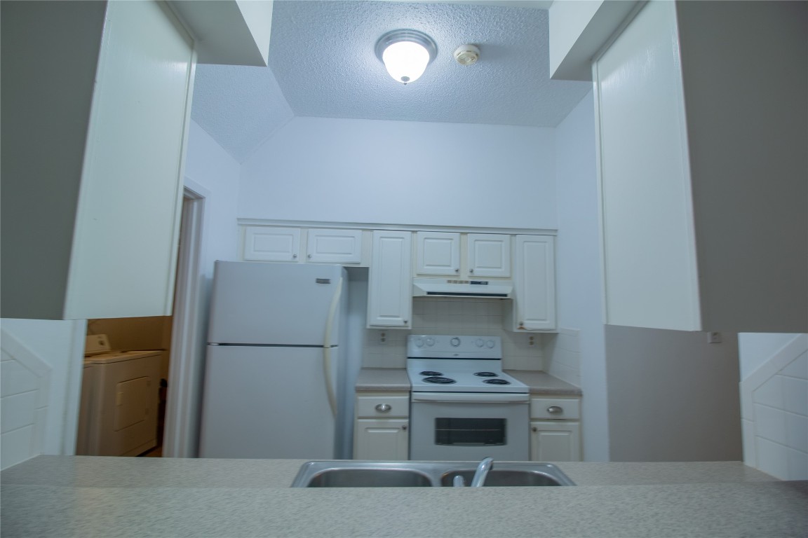 709 Castle Ridge Road, Unit D Austin, TX 78746 - Photo 11 of 19 a kitchen with a refrigerator and a stove