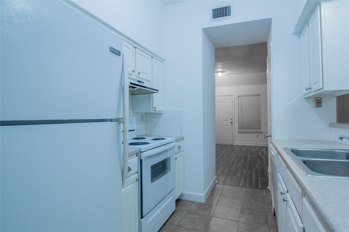 709 Castle Ridge Road, Unit D Austin, TX 78746 - Photo 13 of 19 a kitchen with a sink stove and refrigerator