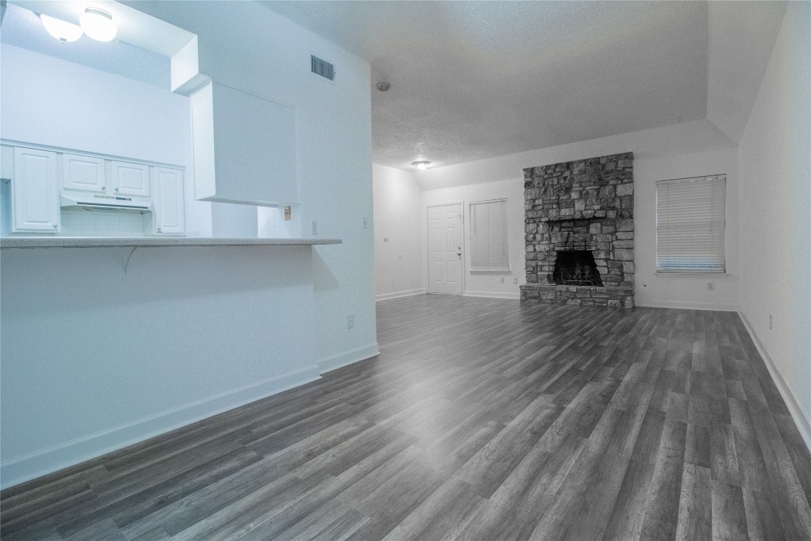709 Castle Ridge Road, Unit D Austin, TX 78746 - Photo 6 of 19 an empty room with wooden floor a cabinet and windows