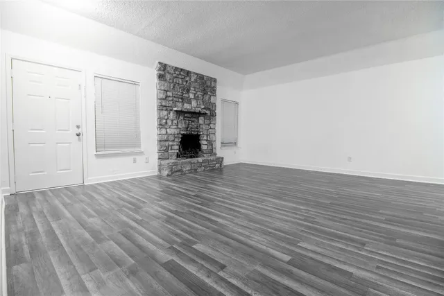 an empty room with wooden floor and fireplace