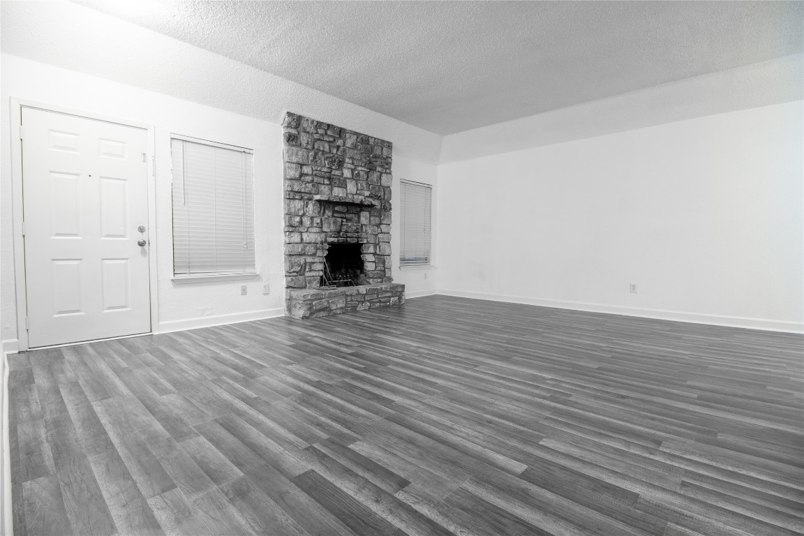 709 Castle Ridge Road, Unit D Austin, TX 78746 - Photo 8 of 19 an empty room with wooden floor and fireplace