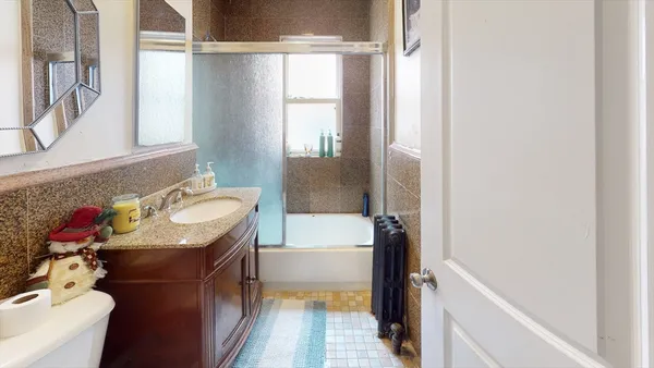 a bathroom with a granite countertop sink toilet and shower