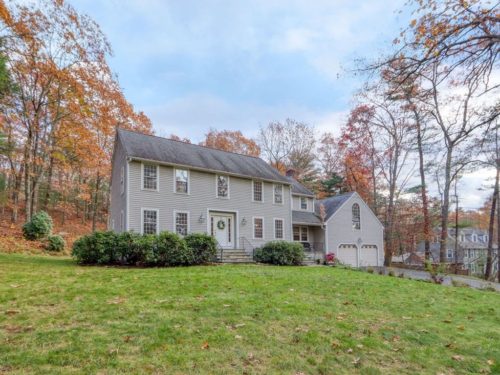 a view of a yard in front of a house with large trees