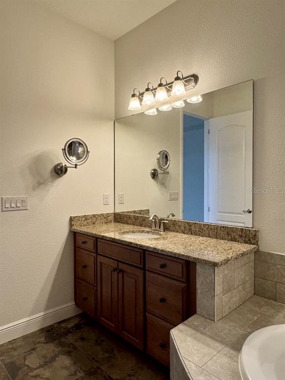 416 Blue Birch Court Sanford, FL 32771 - Photo 19 of 36 a bathroom with a granite countertop sink and a mirror