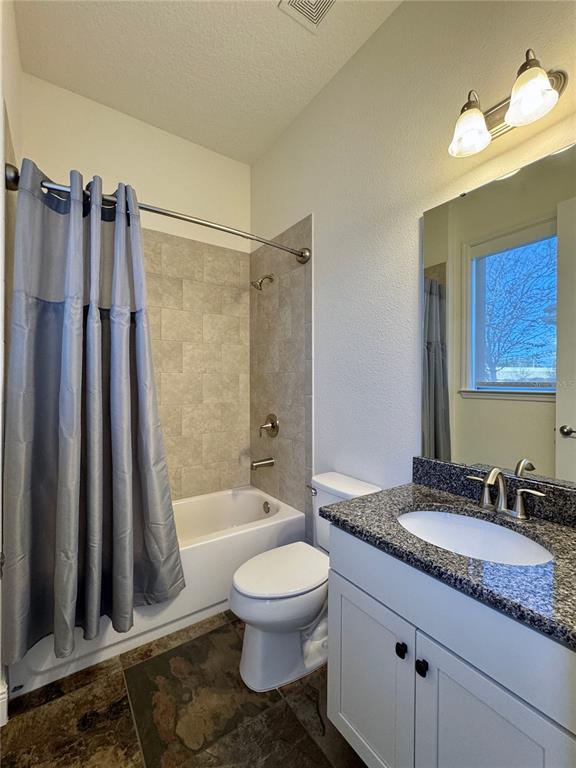 416 Blue Birch Court Sanford, FL 32771 - Photo 22 of 36 a bathroom with a granite countertop sink toilet a mirror a vanity and bathtub