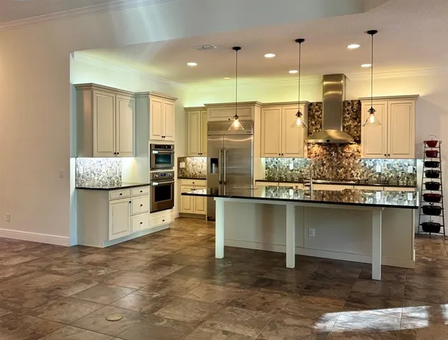 a kitchen with stainless steel appliances granite countertop a stove a sink and a refrigerator
