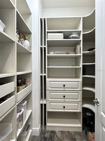 a view of walk in closet with empty racks