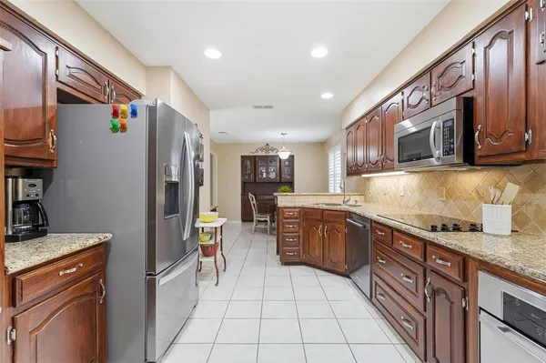 a kitchen with granite countertop a stove top oven microwave and cabinets