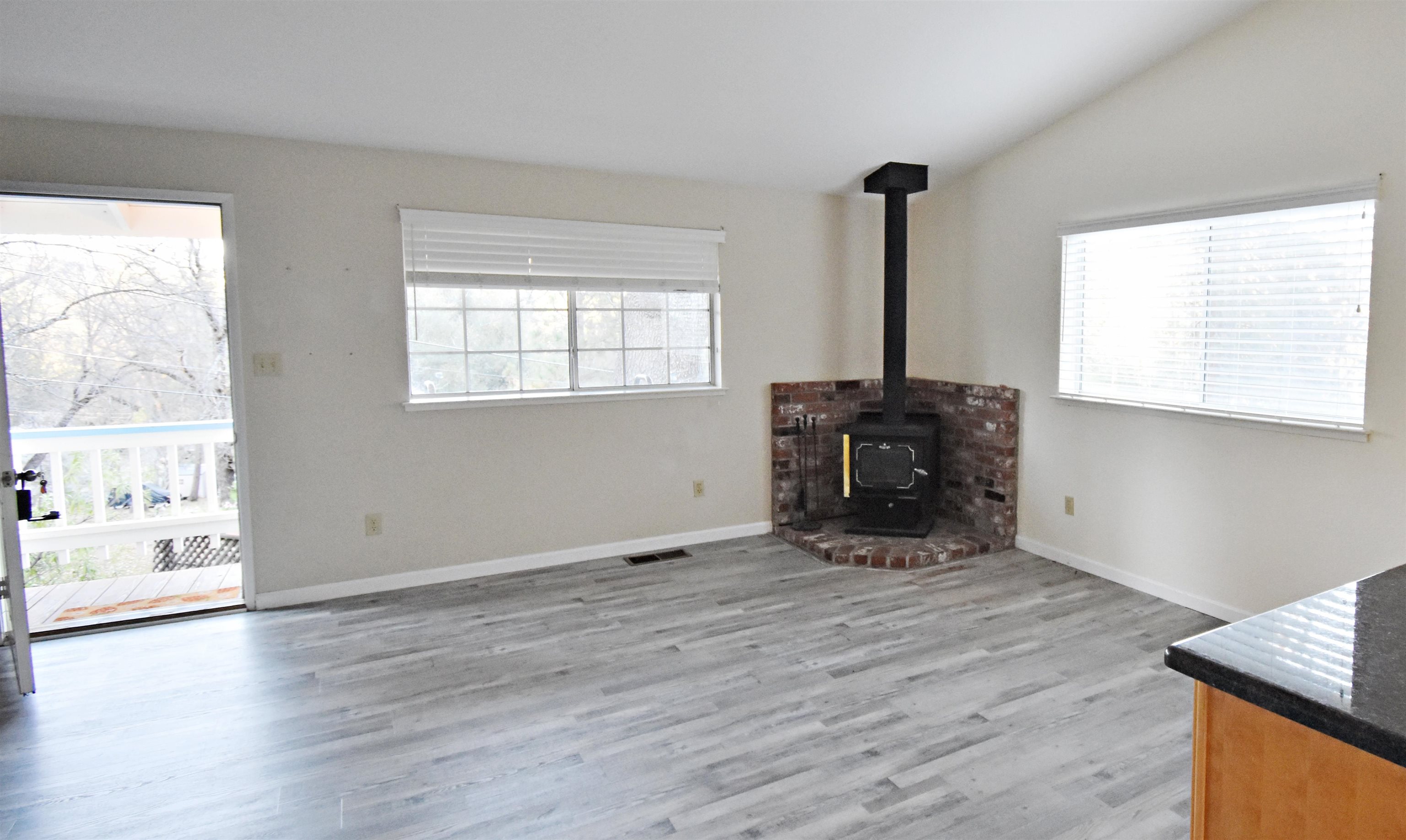 19283 James Circle Groveland, CA 95321 - Photo 7 of 40 an empty room with wooden floor and windows