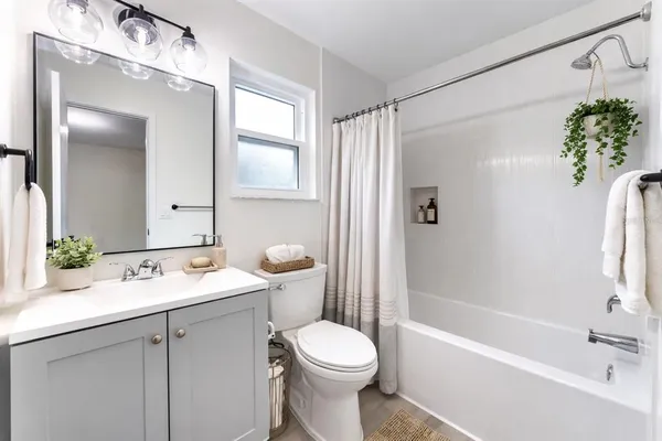 a bathroom with a sink a toilet and shower