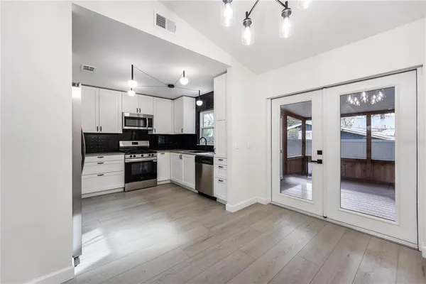 a kitchen with granite countertop a refrigerator and wooden floor
