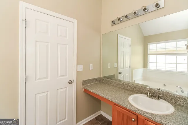 a bathroom with a granite countertop sink and a mirror