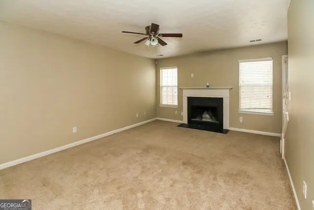 an empty room with fireplace and windows