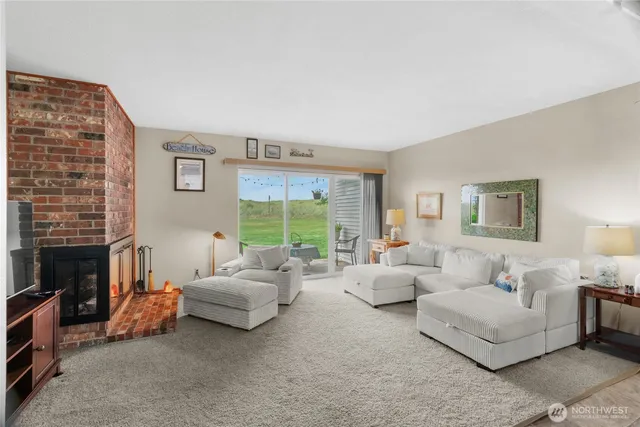 a living room with furniture flat screen tv and a large window