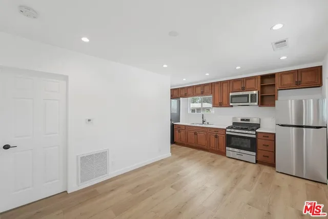 a kitchen with stainless steel appliances a refrigerator and a stove top oven