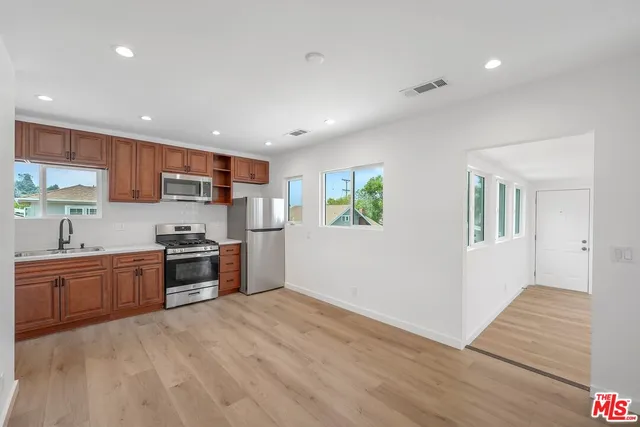 a kitchen with stainless steel appliances granite countertop a refrigerator stove top oven and sink