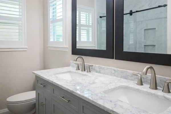 a bathroom with a granite countertop sink a toilet and a mirror