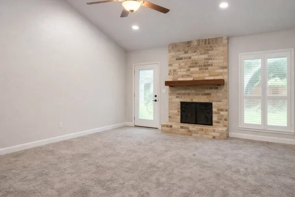 an empty room with a fireplace and fan