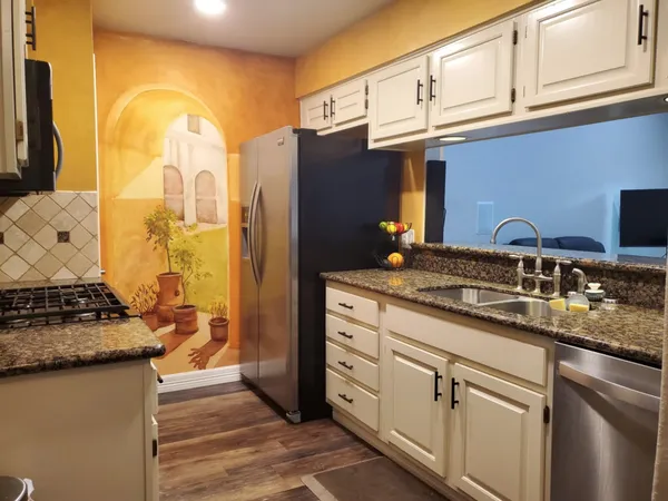 a kitchen with stainless steel appliances granite countertop a sink and a stove