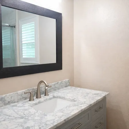 a bathroom with a granite countertop sink and a mirror
