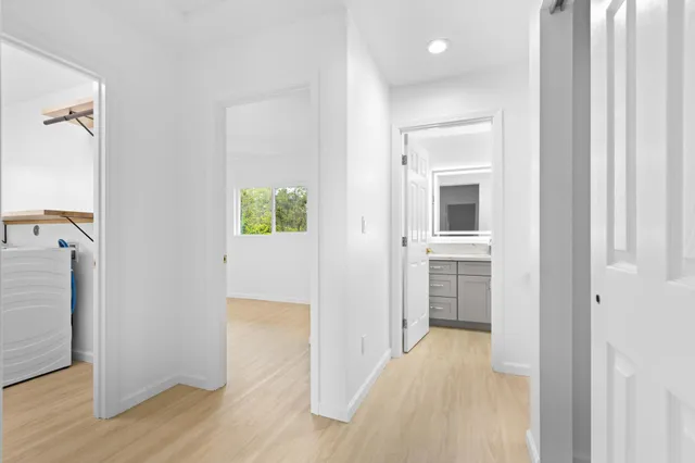 a view of a hallway with wooden floor and closet area