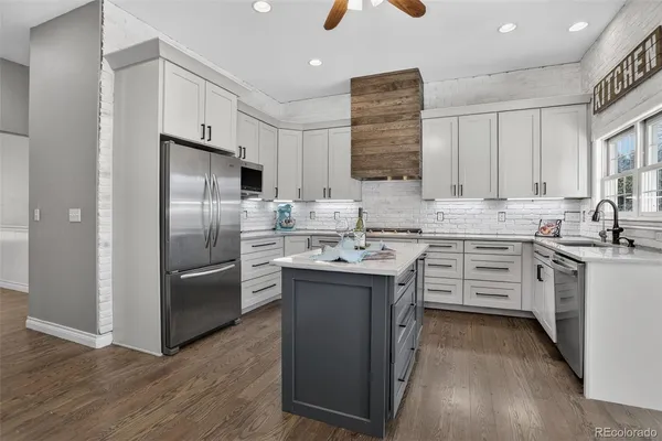 a kitchen with kitchen island granite countertop a sink appliances cabinets and counter space