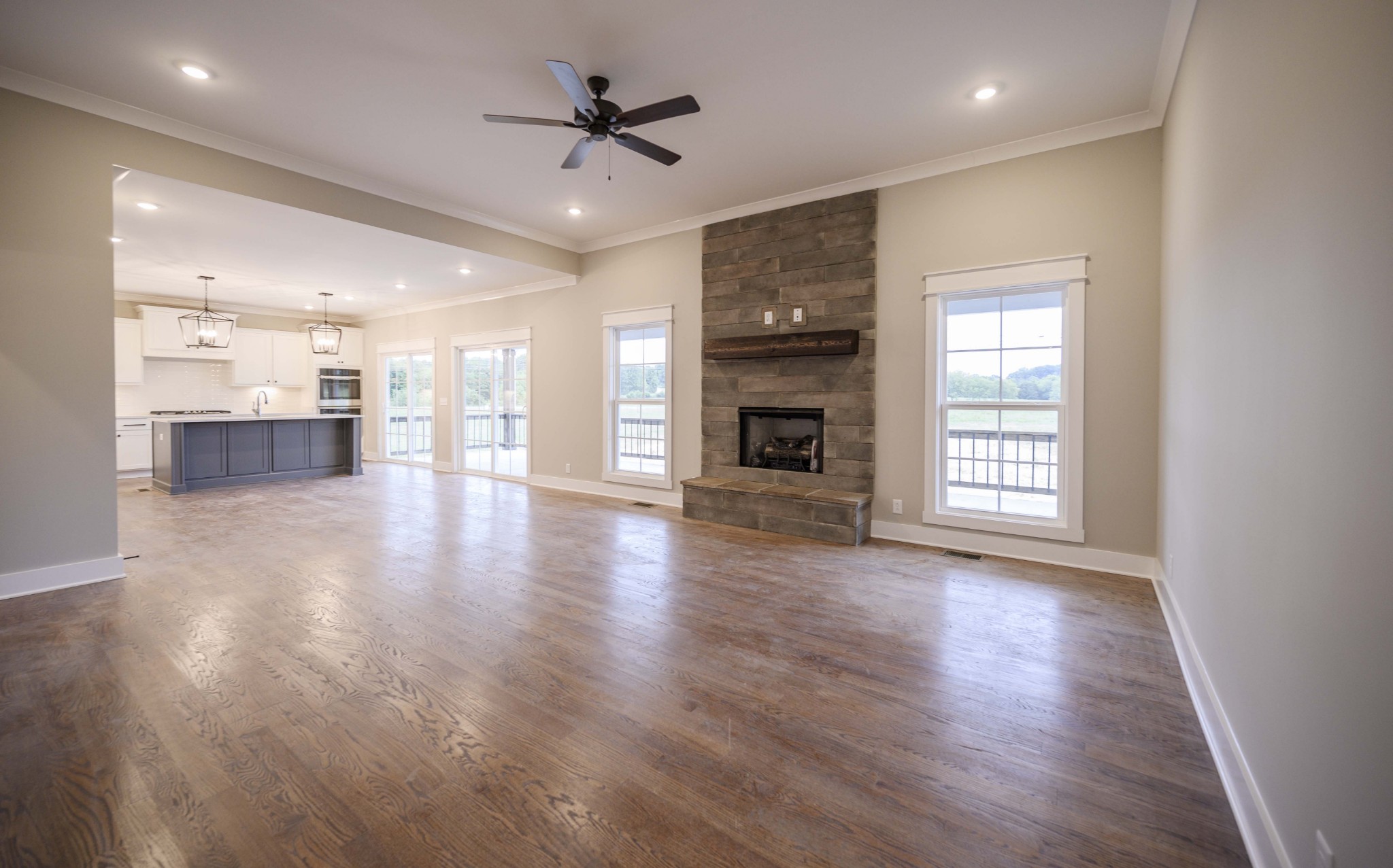 11801 North Milton Road Milton, TN 37118 - Photo 11 of 48 an empty room with wooden floor fireplace and windows
