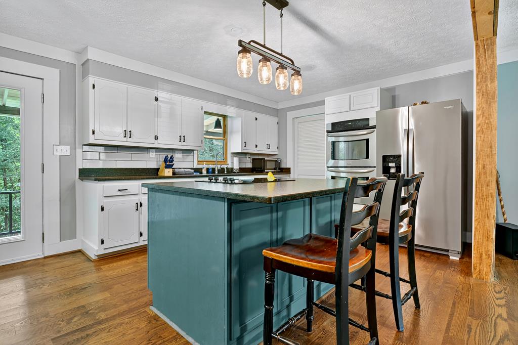 133 Yellowbird Trail Blue Ridge, GA 30513 - Photo 14 of 39 a kitchen with stainless steel appliances granite countertop a stove a sink dishwasher a refrigerator with a dining table and chairs
