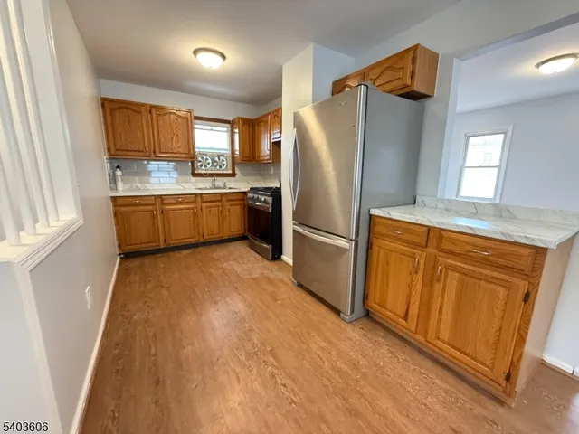 a kitchen with granite countertop a refrigerator and a sink