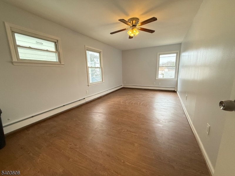 50 Buschmann Avenue, Unit 2 Haledon, NJ 07508 - Photo 8 of 11 an empty room with windows and wooden floor