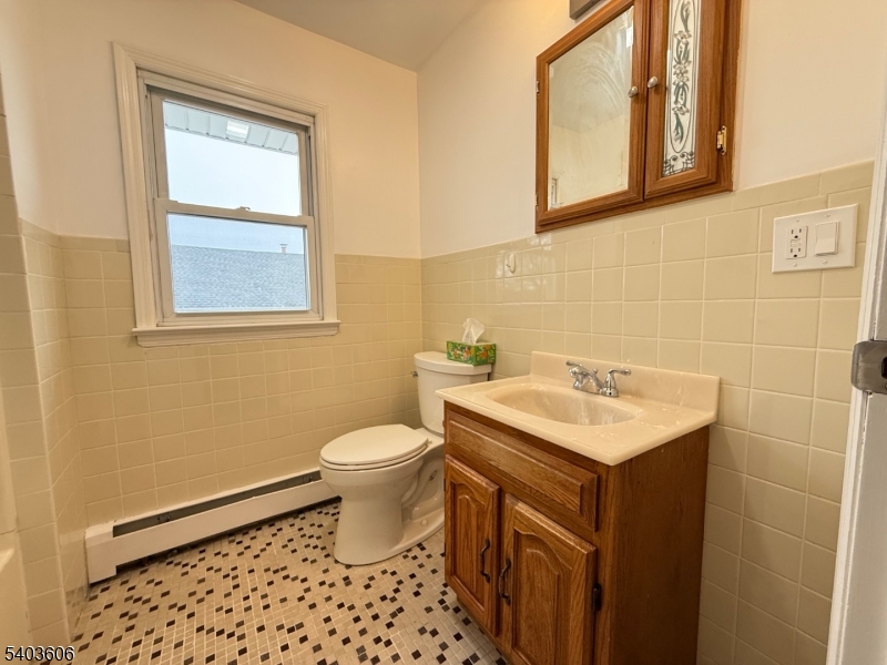 50 Buschmann Avenue, Unit 2 Haledon, NJ 07508 - Photo 10 of 11 a bathroom with a sink a toilet and mirror