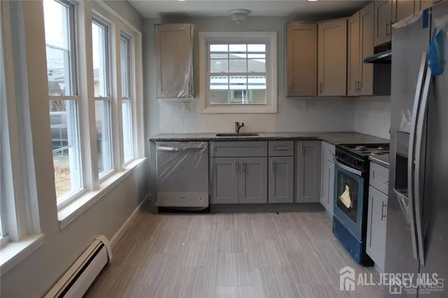 a kitchen with granite countertop a stove a sink and a refrigerator
