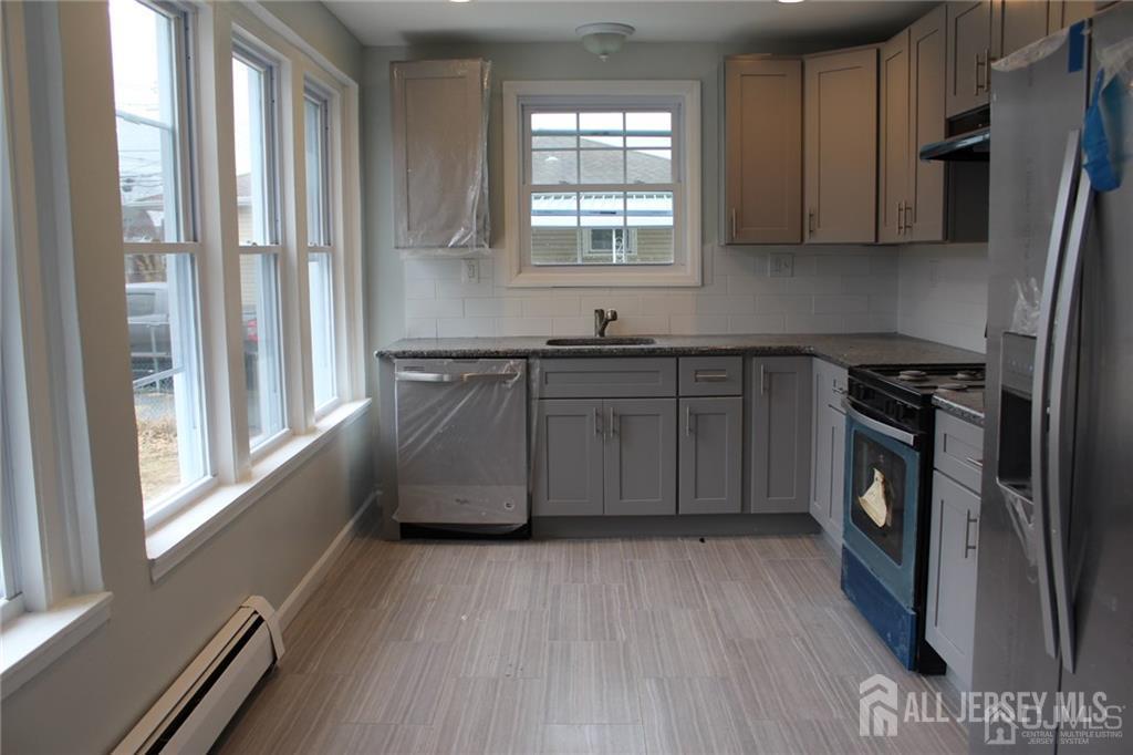 899 Green Street, Unit 1ST F Iselin, NJ 08830 - Photo 3 of 8 a kitchen with granite countertop a stove a sink and a refrigerator