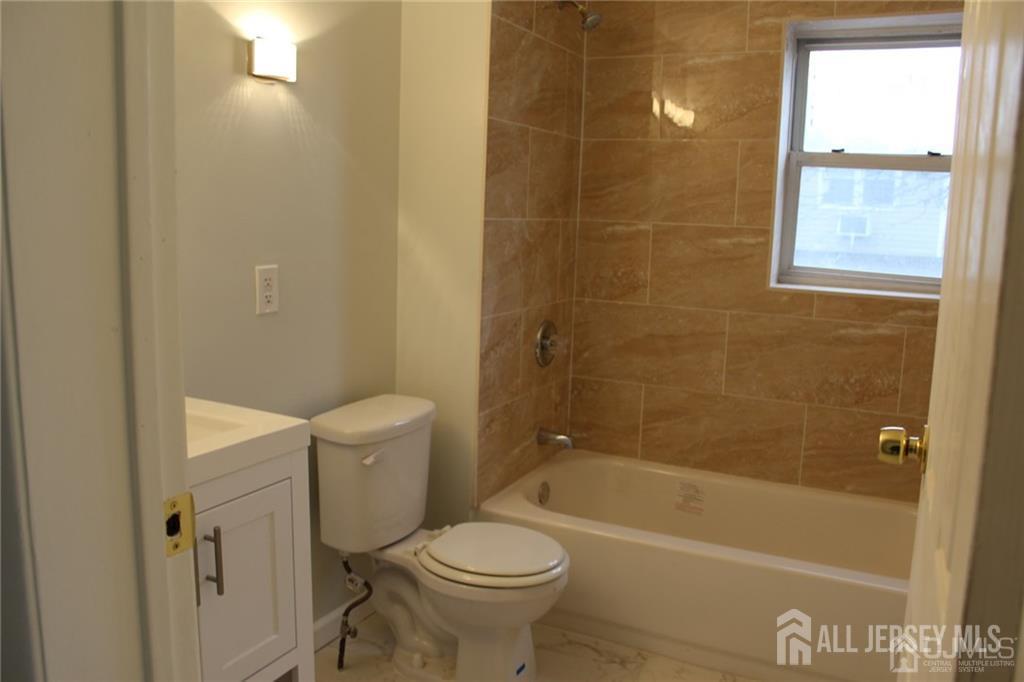 899 Green Street, Unit 1ST F Iselin, NJ 08830 - Photo 6 of 8 a bathroom with a toilet and a bath tub