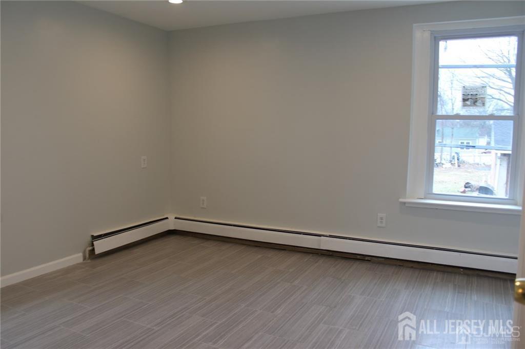 899 Green Street, Unit 1ST F Iselin, NJ 08830 - Photo 7 of 8 a view of a room with wooden floor and a window