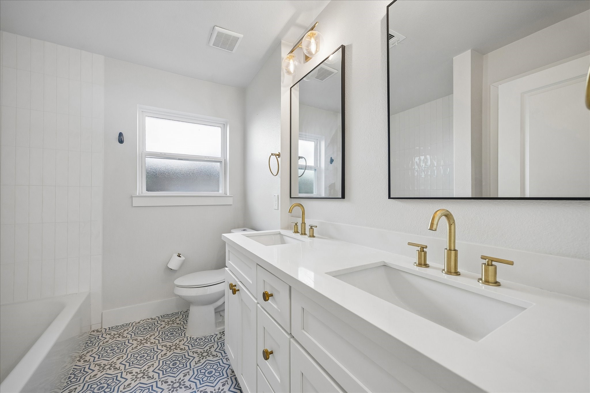 4725 Spellman Road Houston, TX 77035 - Photo 18 of 22 Beautifully renovated secondary bath boasts quartz vanity with dual undermount sinks, stylish tile flooring, framed mirrors & upscale fixtures & hardware!