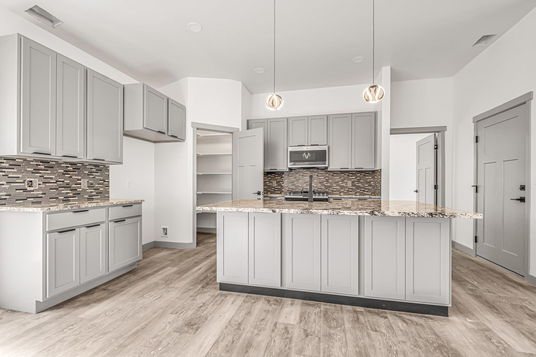 3087 Thunder Cloud Drive Grand Junction, CO 81504 - Photo 7 of 33 a kitchen with stainless steel appliances white cabinets a sink a stove a refrigerator and island