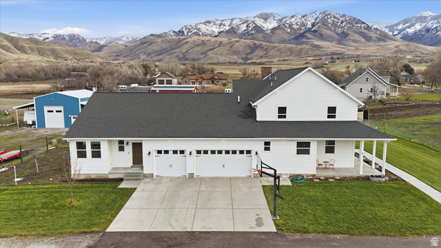 1009 High Creek Road Cove, UT 84320 - Photo 68 of 79 View of front facade with a front lawn, a mountain view, driveway, and covered porch